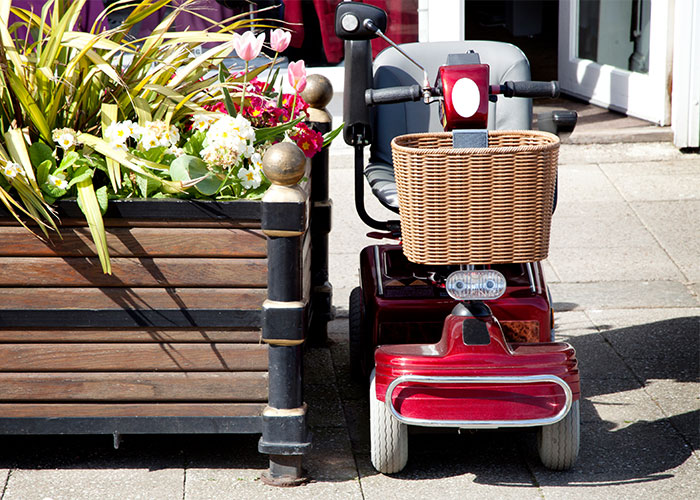 Image of a power mobility wheelchair parked next to a flower basket
